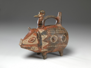 A bottle in the form of a pig for comparison with an oil painting of two pigs with piglets in a sty.